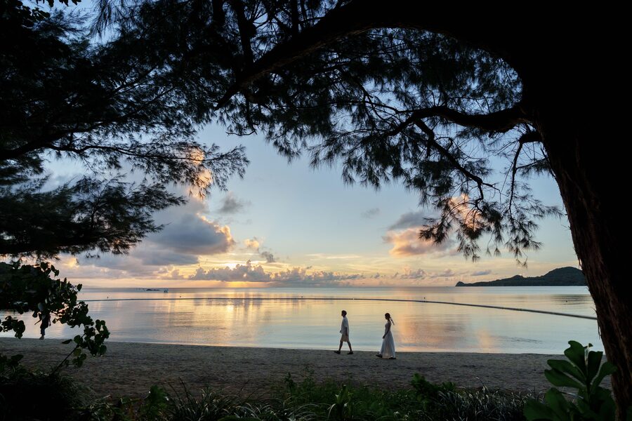 べた凪が撮影した石垣島の夕暮れの海辺を歩く人